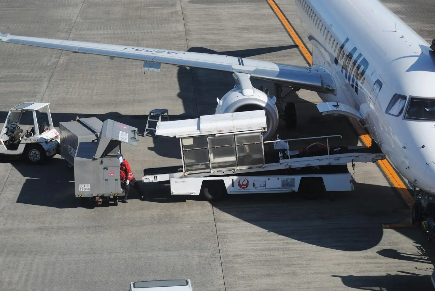Ground crew load cargo into an aircraft hold