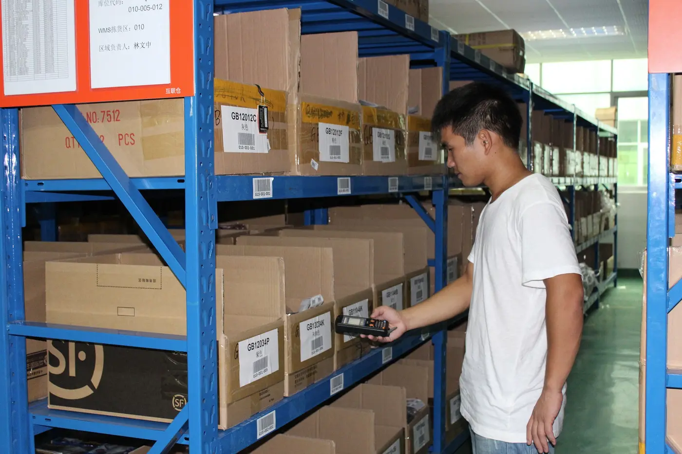A team member scans cartons on the warehouse racking