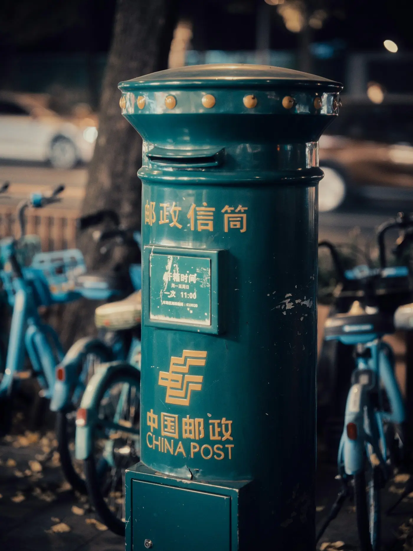 A green China Post letter box on a street