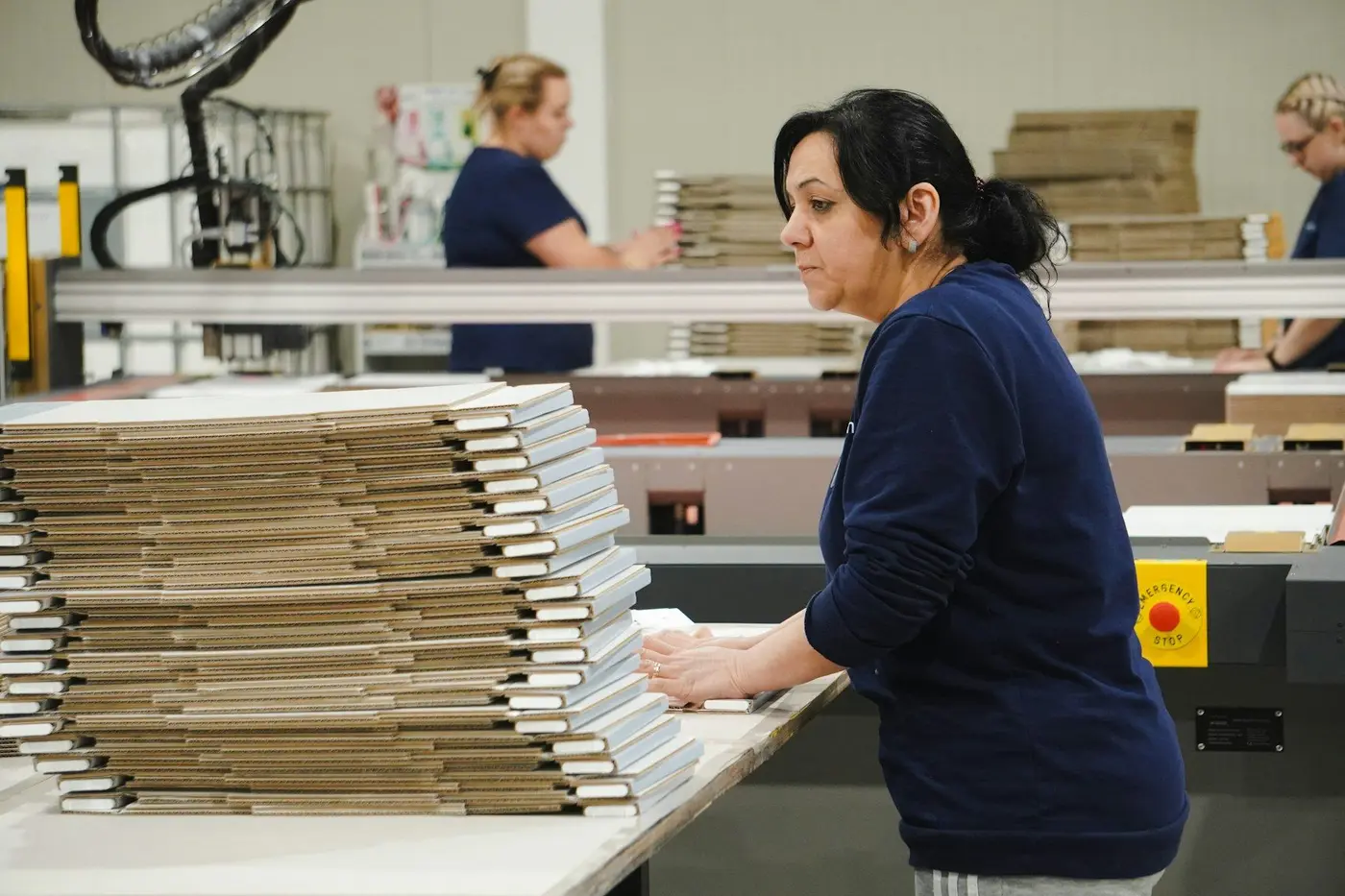 A worker packs parcels at a mail room bench