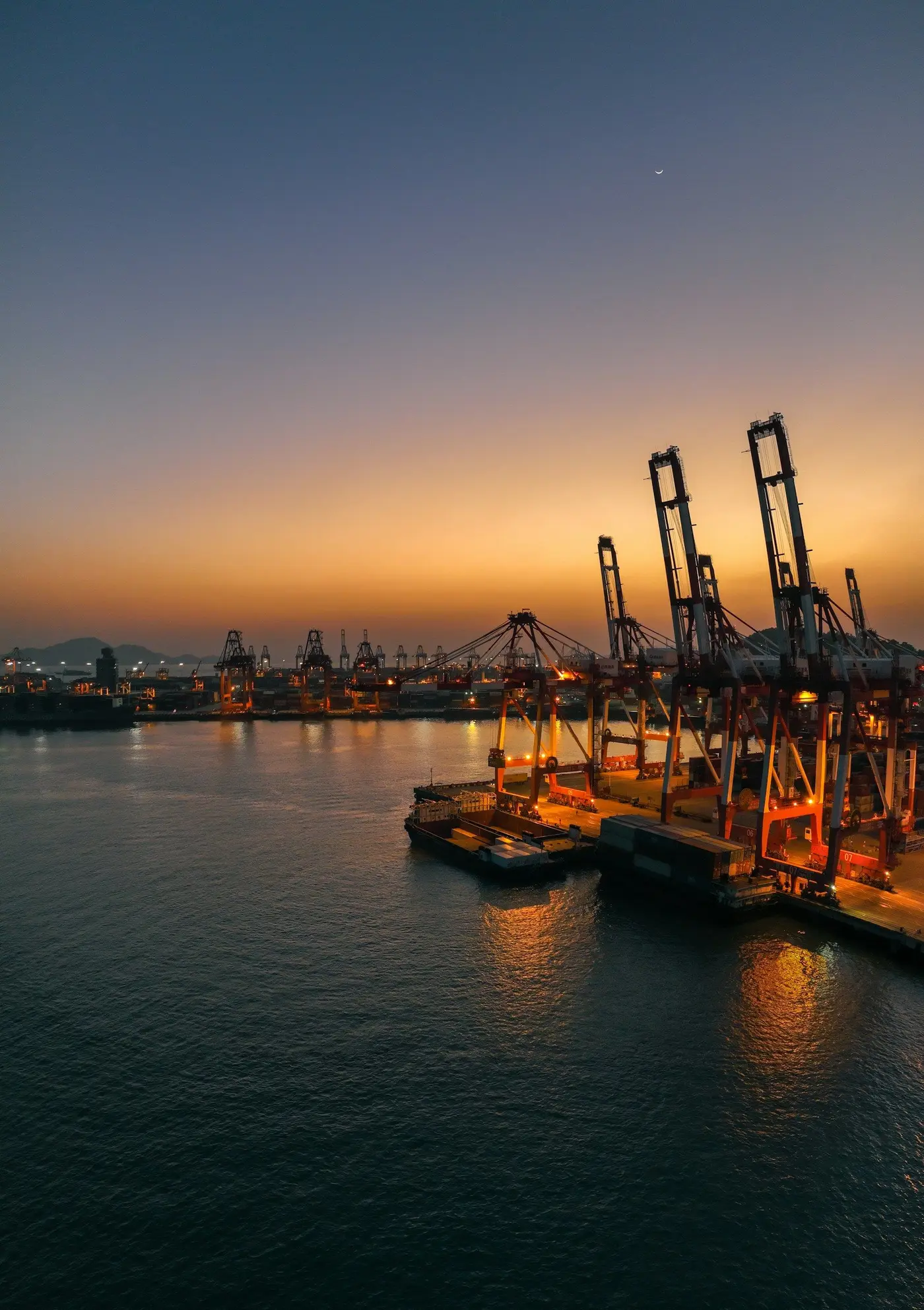 Container cranes at a port at sunset