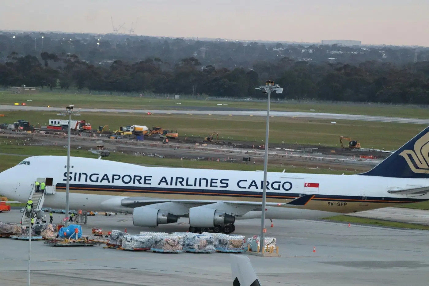 A Singapore Airlines Cargo aircraft on the apron with ground crew