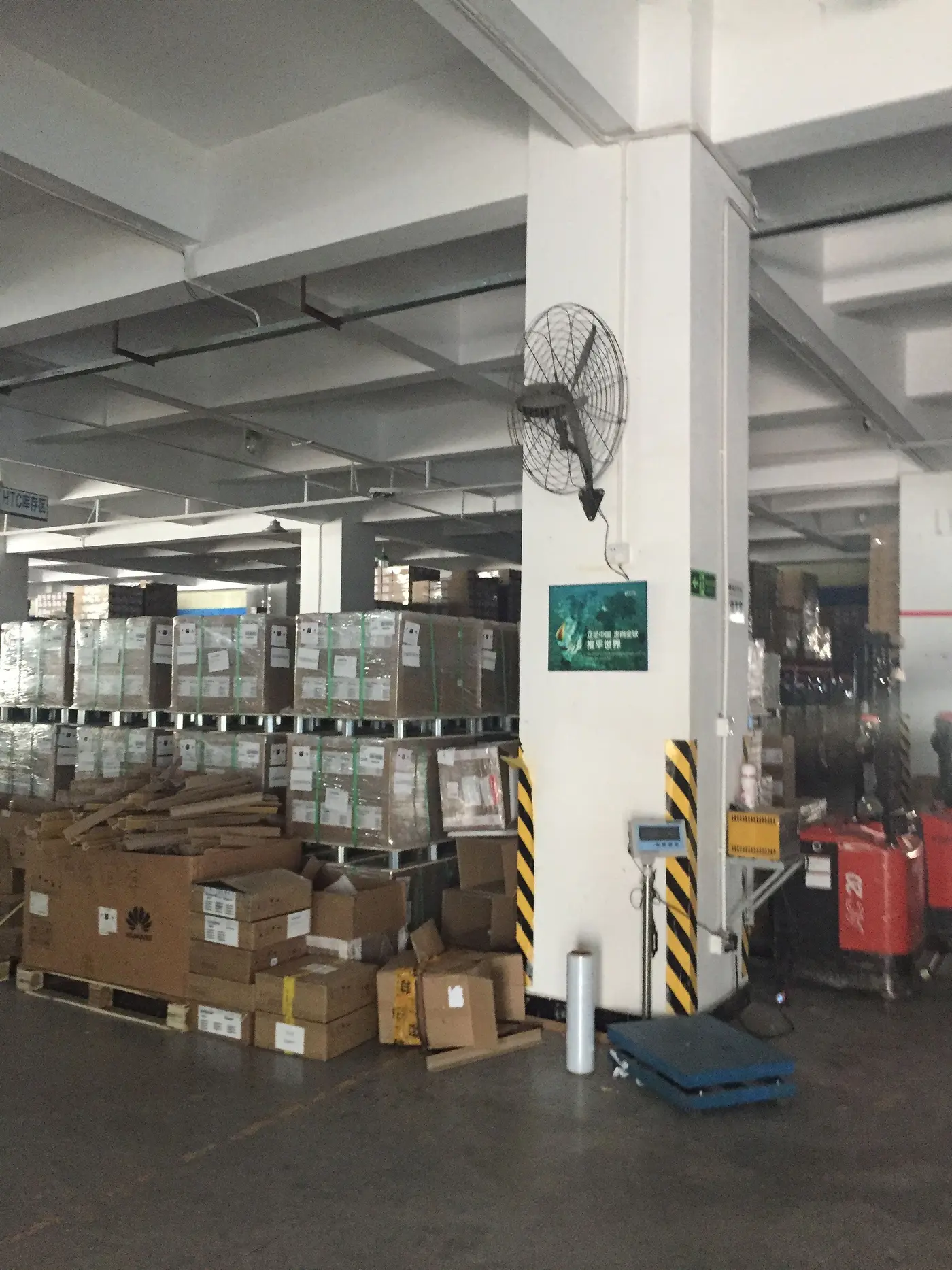 Cartons on pallets in our warehouse, next to a floor scale, for shipping from China to the Netherlands