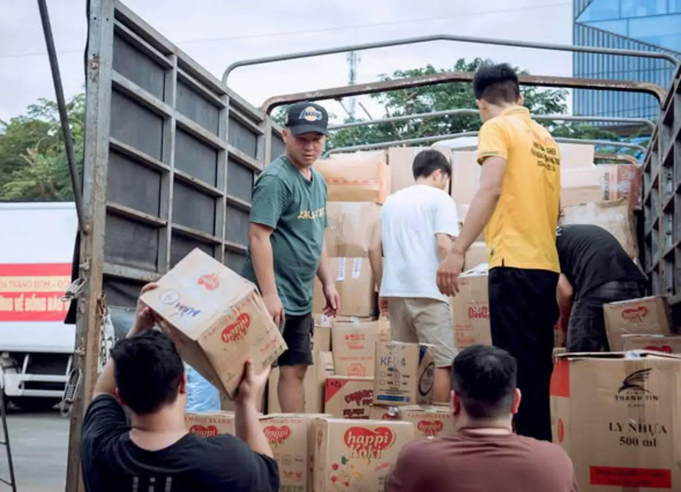Workers load cartons into the back of a truck