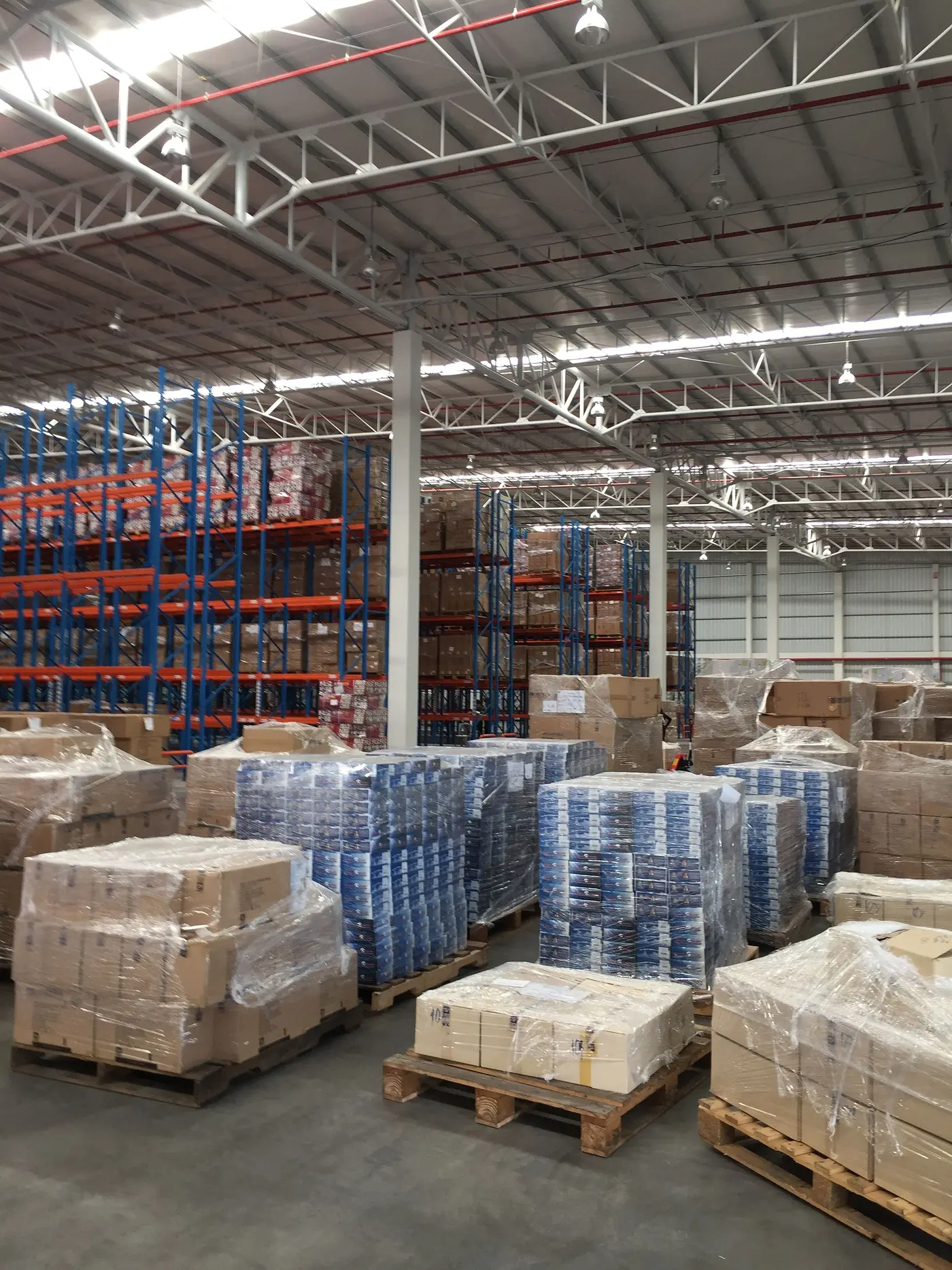 Pallets of goods on a warehouse floor, with racking behind